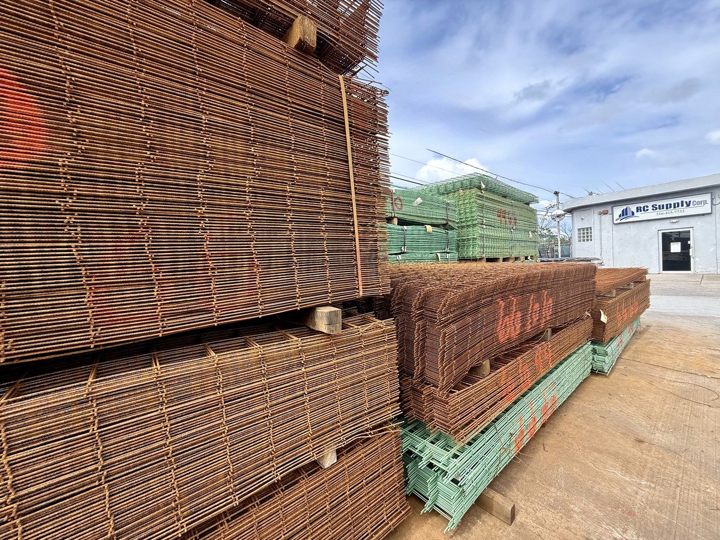 Stacks of plain and epoxy-coated welded wire mesh sheets in the yard at RC Supply Corp in Freeport NY